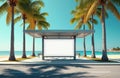 Blank billboard at bus stop. Palm trees frame advertisement on a tropical beach. Clear sky backdrop. Empty space for marketing. Royalty Free Stock Photo