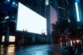 Blank billboard at night in the city with lights and reflections on the wet street Royalty Free Stock Photo
