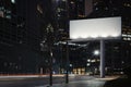 Blank billboard at night time with the city on background. 3d rendering Royalty Free Stock Photo