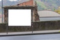 Blank billboard in front of a ruined house