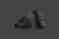 Blank black baby shoes pair mockup on tiptoe, dark background