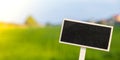 Blank Black billboard against green field landscape Empty mockup template Blackboard label at farm land. Copy space Royalty Free Stock Photo