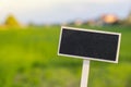 Blank Black billboard against green field landscape Empty mockup template Blackboard label at farm land. Copy space Royalty Free Stock Photo