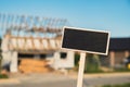 Blank Black billboard against House is in the process of being renovated. Empty mockup template Blackboard label Royalty Free Stock Photo