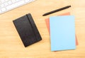 Blank Black,blue and orange notebook ,pen and keyboard on wooden Royalty Free Stock Photo