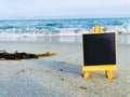 Blank Black board on a beach. Royalty Free Stock Photo