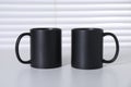 Blank black ceramic mugs on white table. Mockup for design Royalty Free Stock Photo