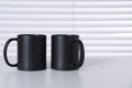 Blank black ceramic mugs on white table. Mockup for design Royalty Free Stock Photo