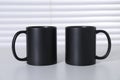 Blank black ceramic mugs on white table. Mockup for design Royalty Free Stock Photo