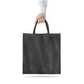 Blank black cotton eco bag design mockup isolated, holding hand
