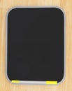 Blank black dry erase board with marker on wood textured background