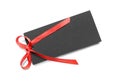 Blank black gift tag with red satin ribbon on white background, top view. Space for design Royalty Free Stock Photo