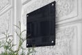 Blank black glass signboard on gray textured wall mockup Royalty Free Stock Photo