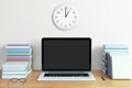 Blank black laptop screen with piles of books on wooden table