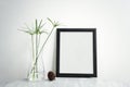 Blank Black Photo Frame and vase on table for Design Mockup