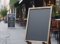 Blank black restaurant shop sign or menu board near the entrance of street cafe at day, neural network generated image Royalty Free Stock Photo