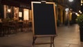 Blank black restaurant shop sign or menu board near the entrance of street cafe at night, neural network generated image Royalty Free Stock Photo