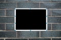 Blank black sign with white frame mounted on a brick wall. Royalty Free Stock Photo
