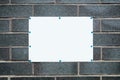 Blank black sign with white frame mounted on a dark gray brick wall. Close up Royalty Free Stock Photo