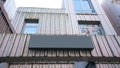 Blank black signboard mounted on weathered wooden facade of building perfectly suited for branding or advertisements