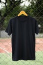 Black t-shirt on wood hanger in outdoor ready for mock up Royalty Free Stock Photo