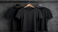 Blank black t-shirts set hanging on hangerâs mockup dark black background Royalty Free Stock Photo