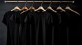 Blank black t-shirts set hanging on hangerâs mockup dark black background Royalty Free Stock Photo