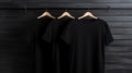 Blank black t-shirts set hanging on hangerâs mockup dark black background Royalty Free Stock Photo