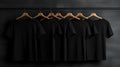 Blank black t-shirts set hanging on hangerâs mockup dark black background Royalty Free Stock Photo