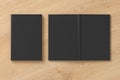 Blank black vertical closed and open and upside down book cover on wooden background isolated with clipping path around cover. Royalty Free Stock Photo