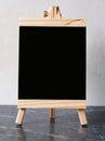 Blank black wooden menu board, chalkboard, standing over white cement wall with copy space, template, Blackboard mock up for Royalty Free Stock Photo