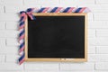 Blank blackboard with bow hanging on brick wall, space for text. USA Royalty Free Stock Photo