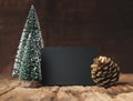 Blank blackboard with christmas tree and gold pine cone and snow falling on grunge wood table and dark brown wooden wall.winter Royalty Free Stock Photo