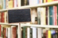 Blank blackboard label and blurred library in the background Royalty Free Stock Photo