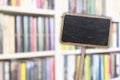 Blank blackboard label and blurred library in the background Royalty Free Stock Photo