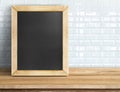 Blank blackboard on tropical wooden table at white tile wall,Template mock up for adding your design and leave space beside frame Royalty Free Stock Photo