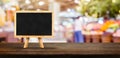 Blank blackborad on wooden table top with blur people shopping at supermarket bokeh background,Mock up for display or montage of Royalty Free Stock Photo