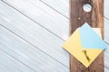Blank, blue note card with yellow envelope on a rustic, textured board with a tiny bouquet of chamomile flowers Royalty Free Stock Photo