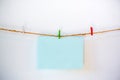 Blank blue notepad hang on the rope by colorful wooden clothes pin for add text. Royalty Free Stock Photo