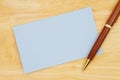 Blank blue paper index card with pen on wood desk Royalty Free Stock Photo