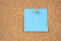 Blank blue paper note pad attached with push pin on wooden background Royalty Free Stock Photo