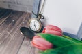 blank blue photo frame with vintage round clock and tulips on brick wall background Royalty Free Stock Photo