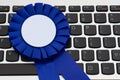 Blank blue prize ribbon on keyboard