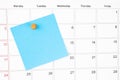 The Blank blue sticky note paper with wooden push pin on calendar page for your text or message Royalty Free Stock Photo