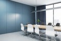 Blank blue wall with place for poster or banner in a meeting room with wooden office desk and chairs, mockup. 3D Rendering Royalty Free Stock Photo