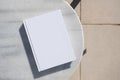 blank book for mockup design on marble table by the swimming pool