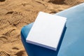 blank book mockup on lounge on sandy beach