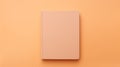 A blank book on a plain orange background, peach fuzz, trendy color of the year 2024.
