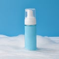 Blank bottle in cleansing foam on blue background