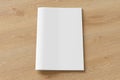 Blank brochure or booklet cover mock up on wooden background. Isolated with clipping path around brochure. Front view. Royalty Free Stock Photo